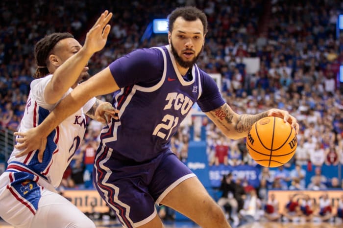 TCU Horned Frogs forward JaKobe Coles (21) drives around Kansas Jayhawks guard Bobby Pettiford Jr. (0) during the first half at Allen Fieldhouse.